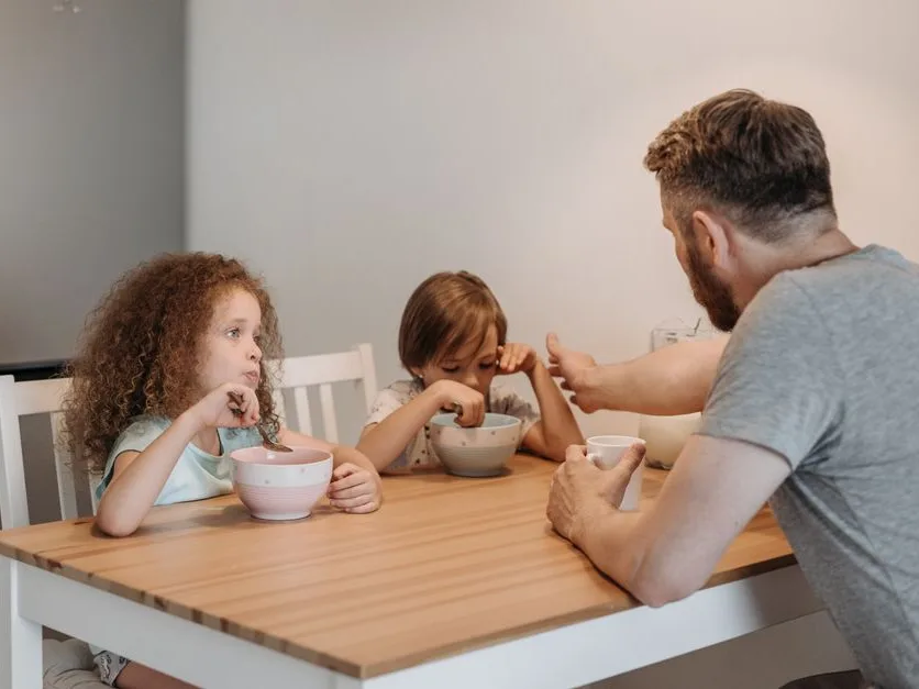 Un père et ses enfants autour de la table de la cuisine